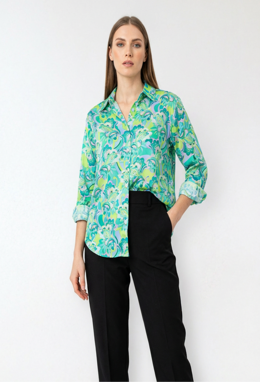 Woman wearing a green floral shirt and black pants.
